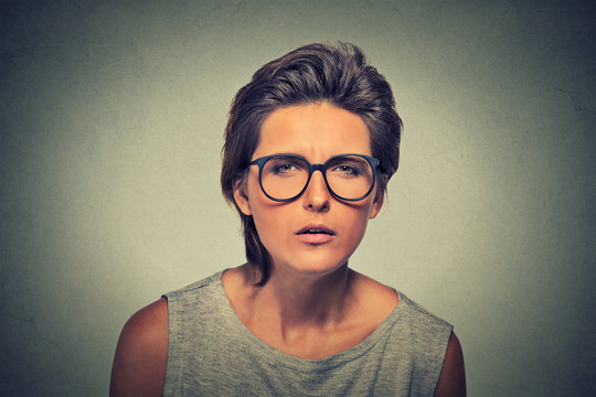 Displeased unsure arguable suspicious thinking young lady in glasses