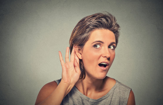 surprised young nosy woman hand to ear gesture secretly listening