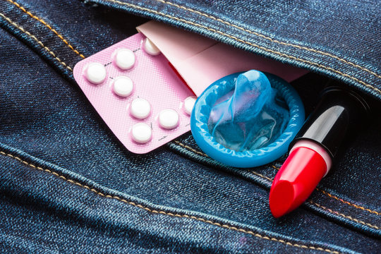 Pills condom and lipstick in denim pocket.