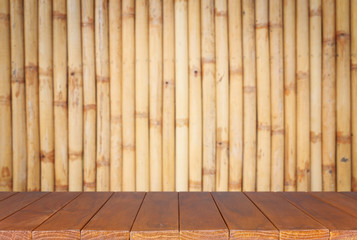 Empty top wooden shelves and bamboo wall background