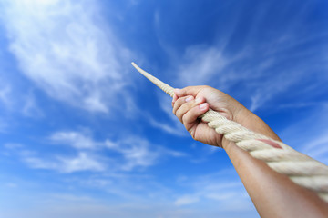 Close up hand holding rope on blur sky
