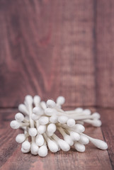 White cotton bud or cotton swab over wooden background