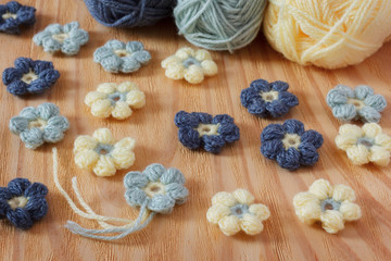 Fototapeta na wymiar Handmade colorful crochet flower with skein on wooden table. Selective focus