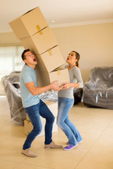 young couple with falling stack of boxes