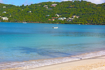 Beautiful tropical beach of Thomas Islands in early morning, US Virgin Islands. Turquoise waters, hillside and a long palm shadow at the beach of tropical island.