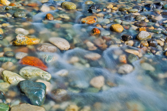 Pebble stones in the river water close up view,