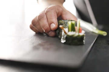 Sushi z łososiem, krewetką i ogórkiem. Klasyczne  grube rolki futomaki podane na kamiennym talerzu