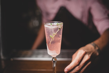 le barman sert un cocktail rose pétillant