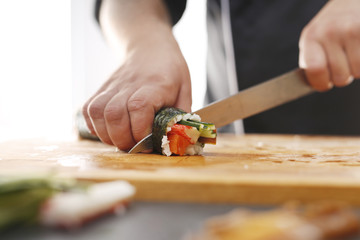 Sushi futomaki.Sushi master kroi nożem rolki sushi