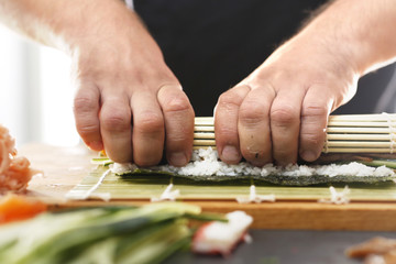Zwijanie rolek sushi w bambusowej macie, etapy tworzenia. - obrazy, fototapety, plakaty