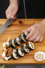Sushi.Sushi master kroi nożem rolki sushi