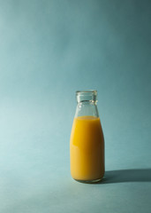 Glass of Orange Juice on Teal Background