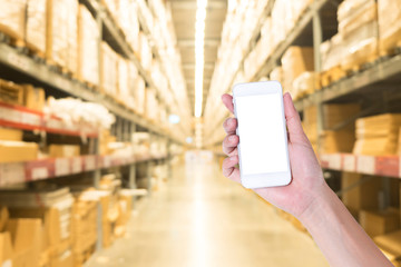 woman hand showing smart phone with warehouse background