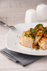 Fish with vegetable marinade on the ceramiс plate with fork