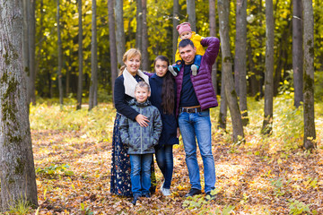 Fototapeta premium cute family in a park on an autumn