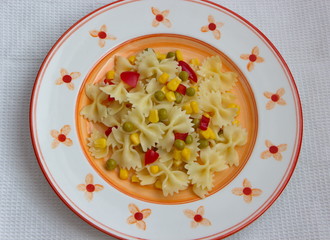 farfalle with vegetables served on painted plate