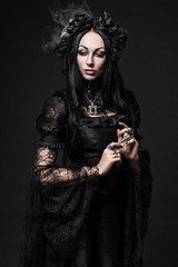 Portrait of beautiful Gothic woman in dark dress in studio