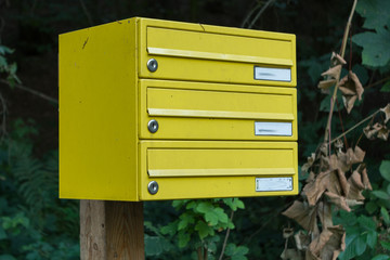 gelber Postkasten mit mehreren Fächern