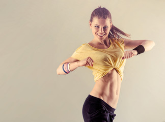 Aerobics fitness workout. Young athletic female dancing street dance in studio.  Concept of sport and health. 