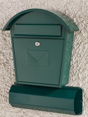 grüner Briefkasten und Zeitungsrolle