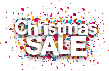 Christmas sale paper sign over confetti.