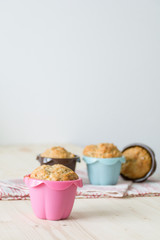 Muffins in colorful muffin cups on table