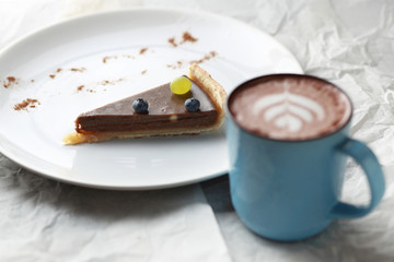 Cup of cacao and a piece of cake. Latte art.