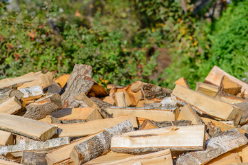 chopped firewood, scattered pile in sunny day. Shallow depth of