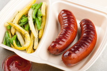 Grilled sausages with french beans in the lunch box