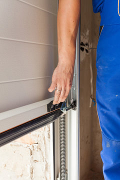 Worker Open A Garage Door During Installation