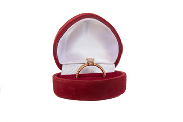 Gold ring in a red heart-shaped box © dbachinskiy
