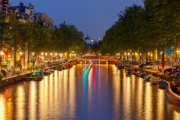 Embankment and canal of Amsterdam at night.