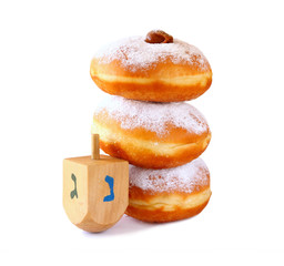 image of jewish holiday Hanukkah with donuts and wooden dreidel (spinning top). isolated on white
