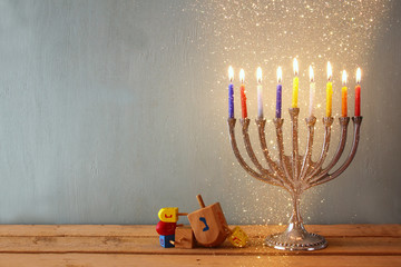 low key image of jewish holiday Hanukkah with menorah (traditional Candelabra) and wooden dreidels...