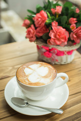 Hot latte art coffee cup on table, vintage and retro style.