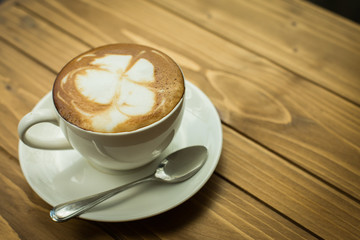Hot latte art coffee cup on table, vintage and retro style.