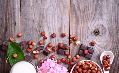 Fresh hazelnut and dark chocolate on wooden background