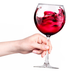 Glass of red wine with splashes in hand isolated