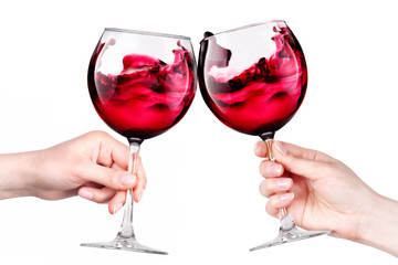 Glasses of red wine with splashes in hand isolated