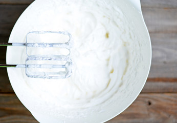 Fototapeta na wymiar Whipped egg whites for cream on wooden table