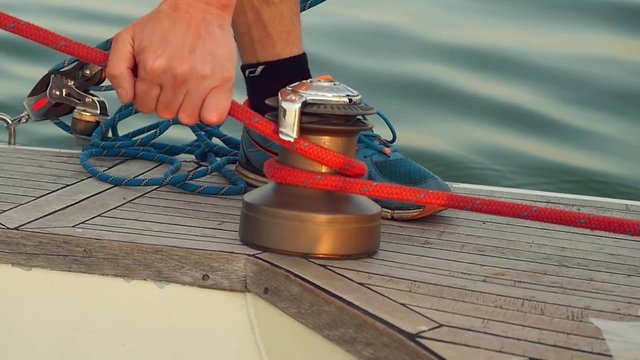 Ships boy knotting  rope on a boat in slowmotion