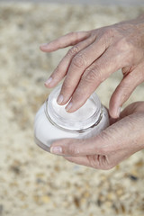 Frau cremt sich die Füße ein