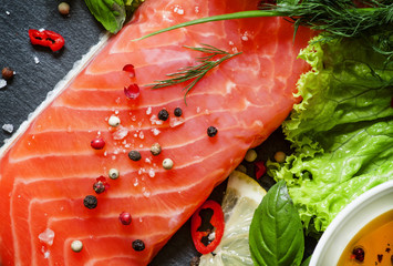 Tasty piece of salmon fillet with herbs, spices, lemon, salt, pe