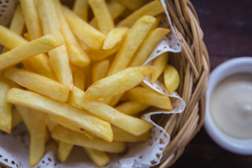 French fries in the wood basket with sauce, selective focus poin