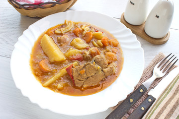 Chicken stew with potatoes in plate on white table