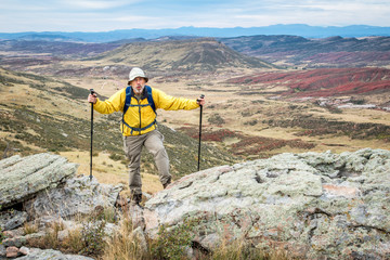 senior male hiker on rocky cliff