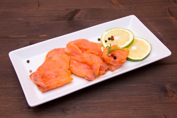 Smoked salmon on tray on wooden table