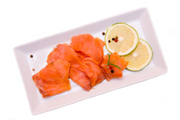 Smoked salmon on tray on white background seen from above