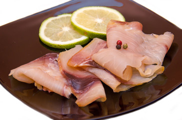 Smoked swordfish on black plate on a white background seen close