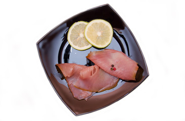 Smoked tuna on black plate on a white background seen from above